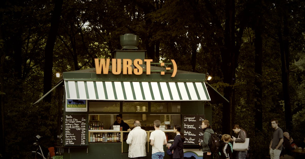 Charming outdoor kiosk serving Wurst with people queuing on a sunny day.