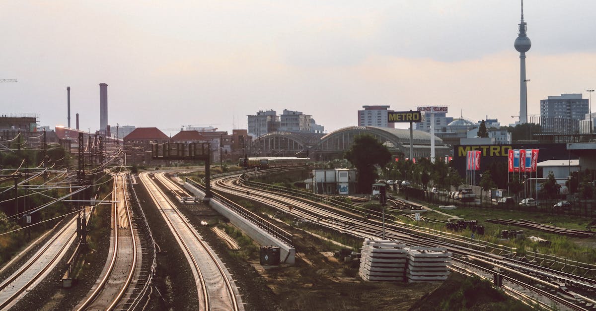Urban railway in Berlin with TV tower visible at sunset, showcasing city transport.