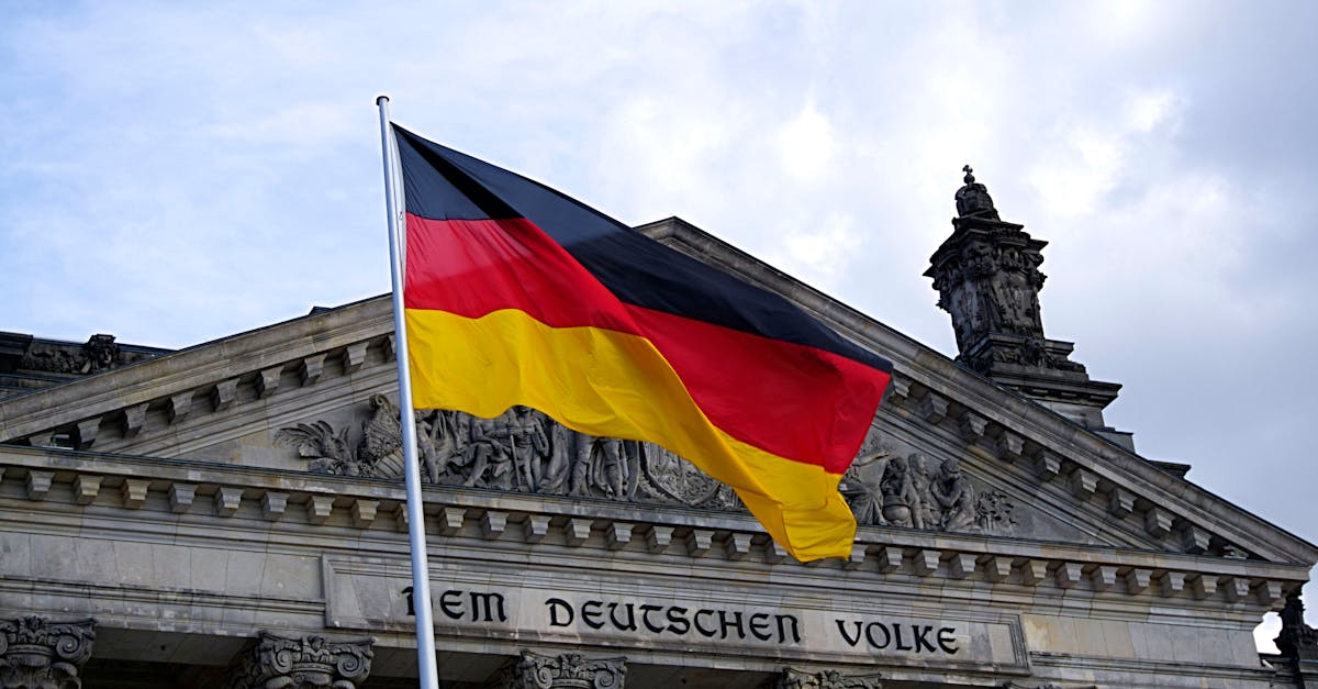 German national flag waving in front of the Reichstag building in Berlin, a symbol of democracy.