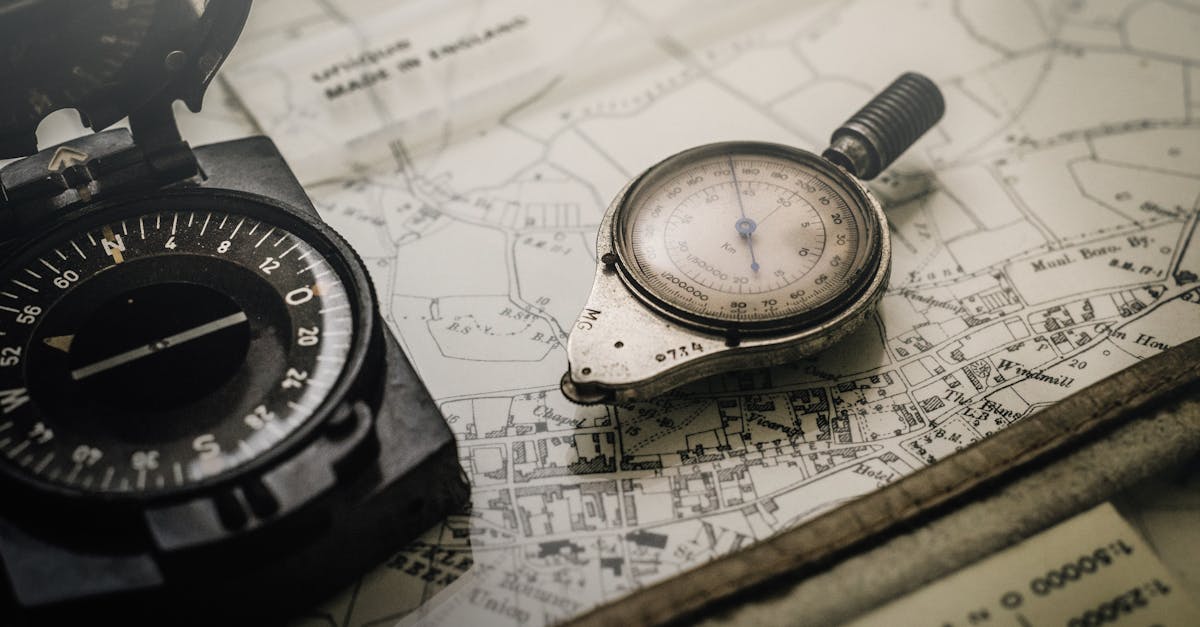A vintage compass and navigation instrument on an old map, showcasing precision tools for exploration.