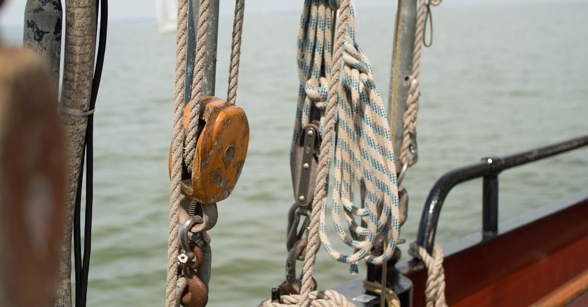 Detailed view of ropes and pulleys on a boat sailing in the open sea under a clear sky.