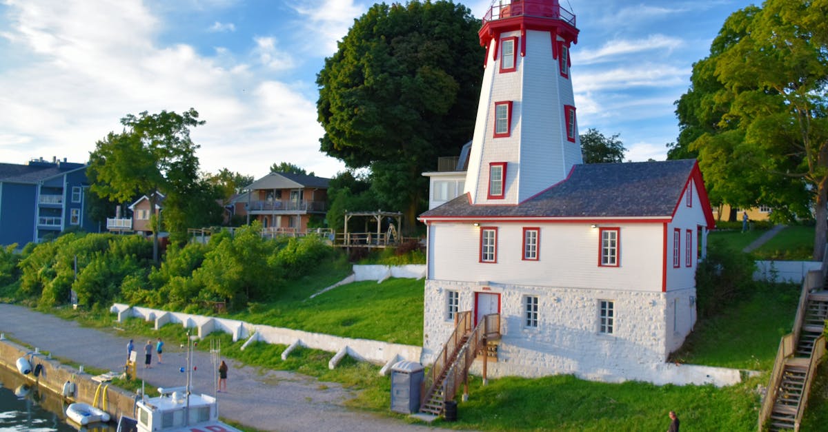 Breathtaking view of Kincardine Lighthouse by the serene lakeshore on a sunny day.