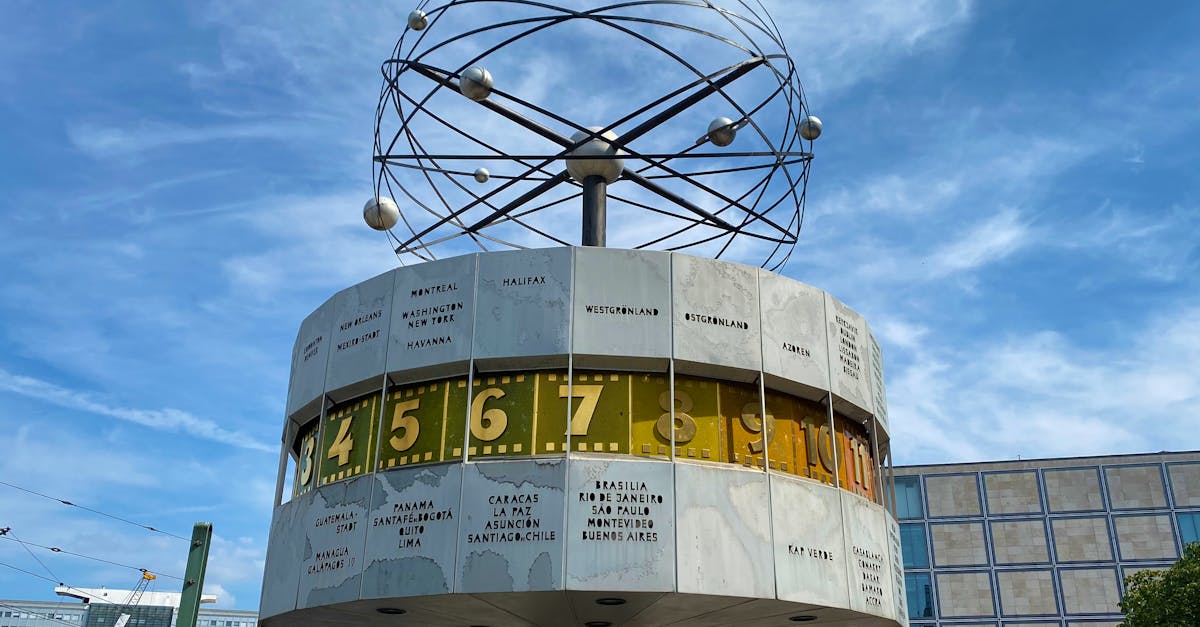 Iconic image of Berlin's World Clock at Alexanderplatz under a vibrant blue sky.