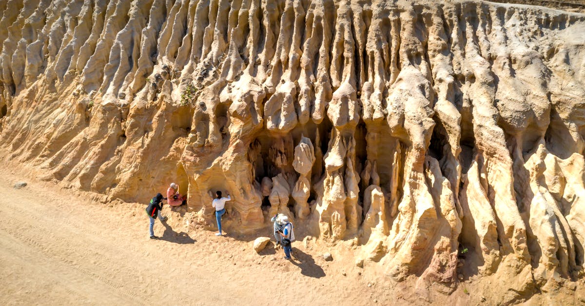 Aerial view of people exploring sandstone rock formations with interesting textures.