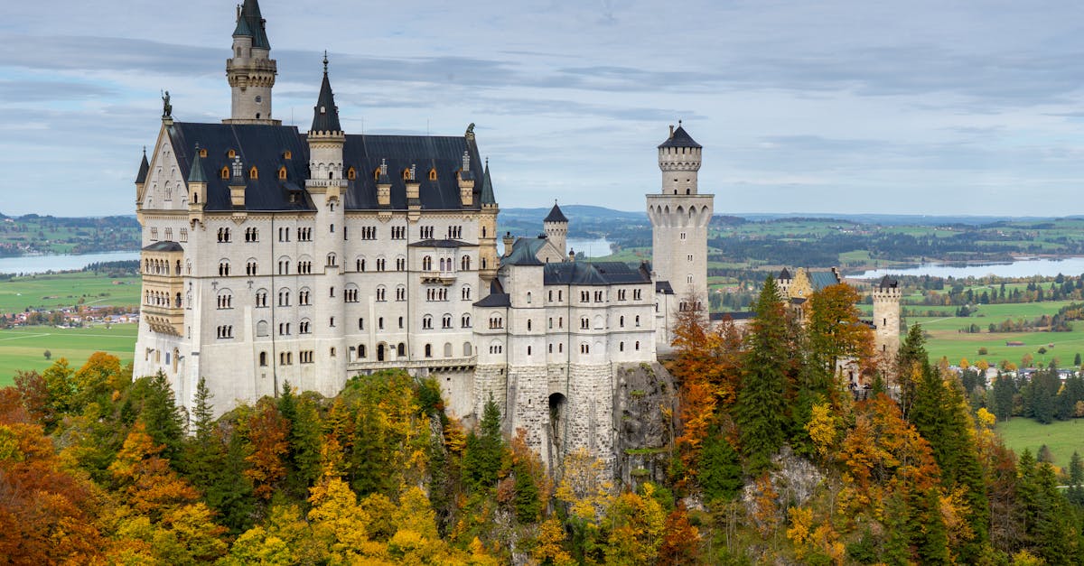 Aerial view of the iconic Neuschwanstein Castle surrounded by vibrant autumn foliage in Bavaria, Germany.
