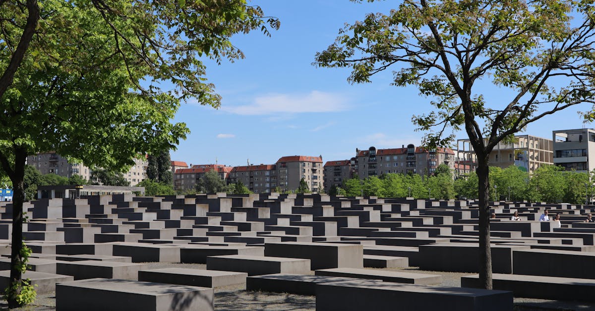 Holocaust Memorial in Berlin, Germany, with trees and clear sky.