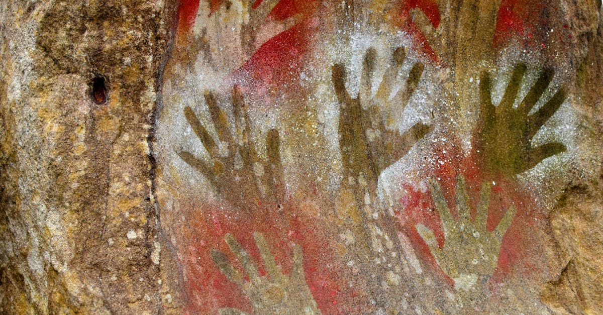 Neolithic hand print art painted on cave wall illustrates ancient history.