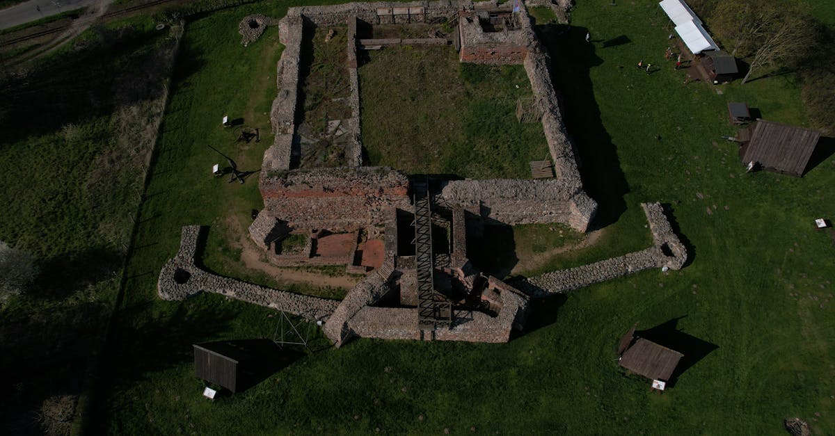 Aerial photograph showcasing the ancient stone ruins of a medieval castle in rural Poland.