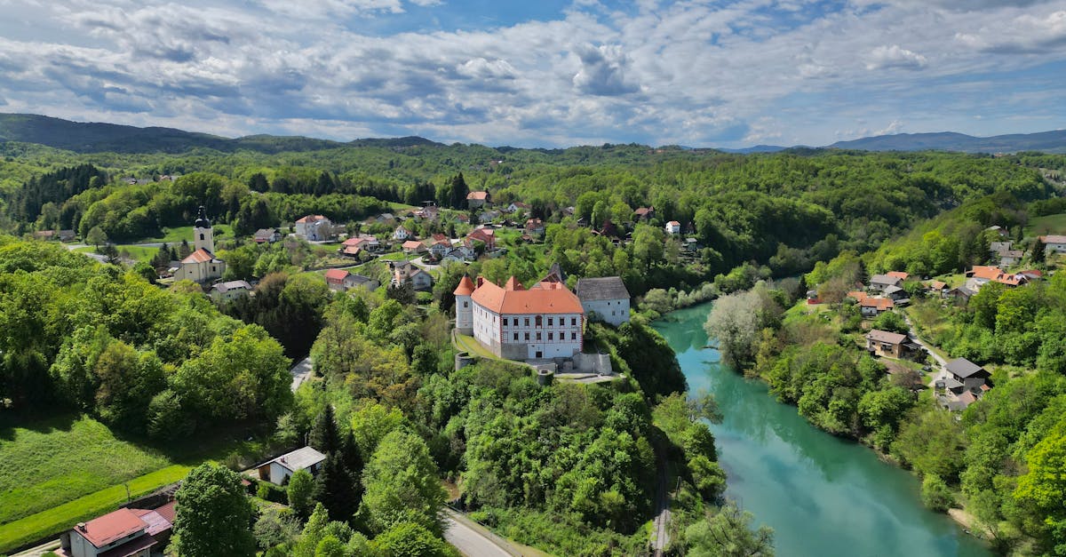 Stunning aerial view of Ozalj Castle and lush landscape along the Kupa River in Croatia.