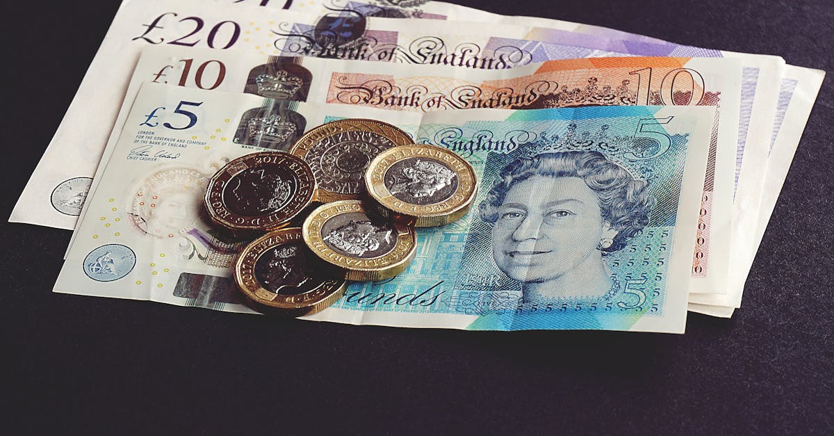 High-quality image of British pound notes and coins on a dark surface, showcasing currency detail.