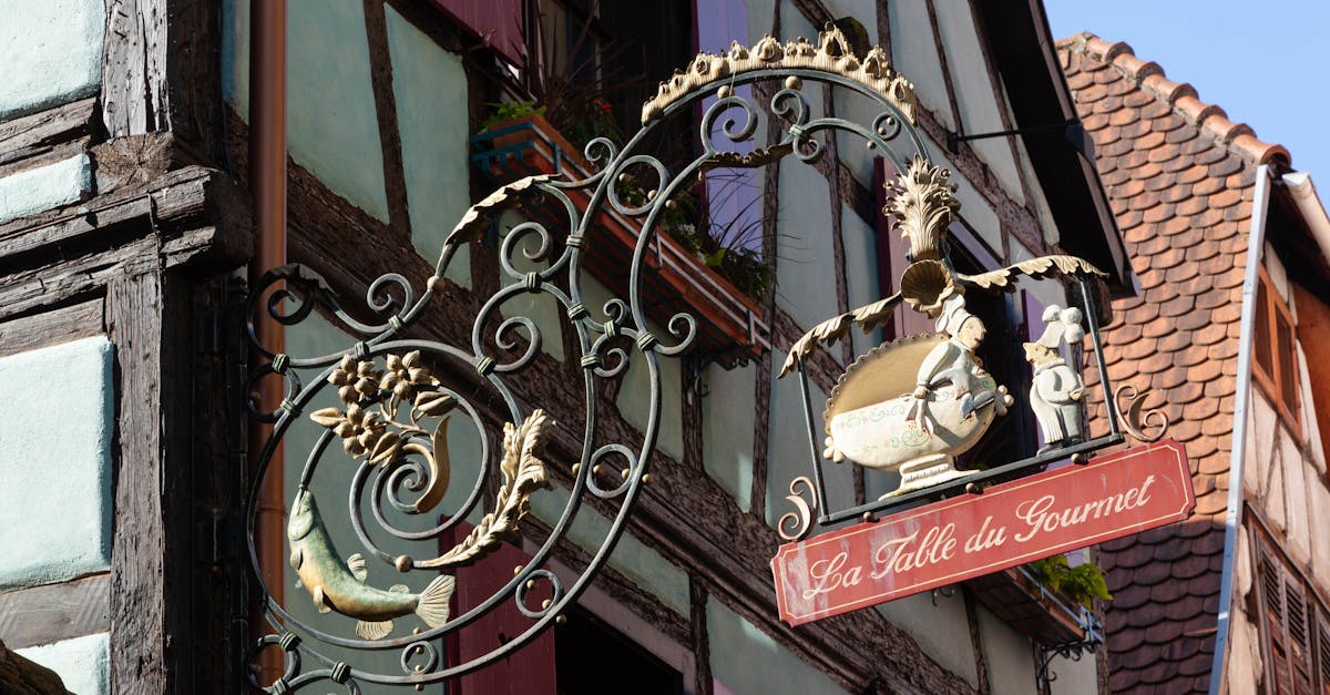 Ornate vintage restaurant sign in Riquewihr, France showcasing iconic Alsace architecture.