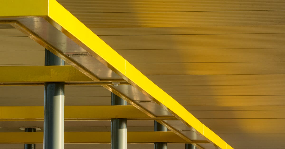 Artistic low-angle view of modern yellow structural beams against a ceiling.