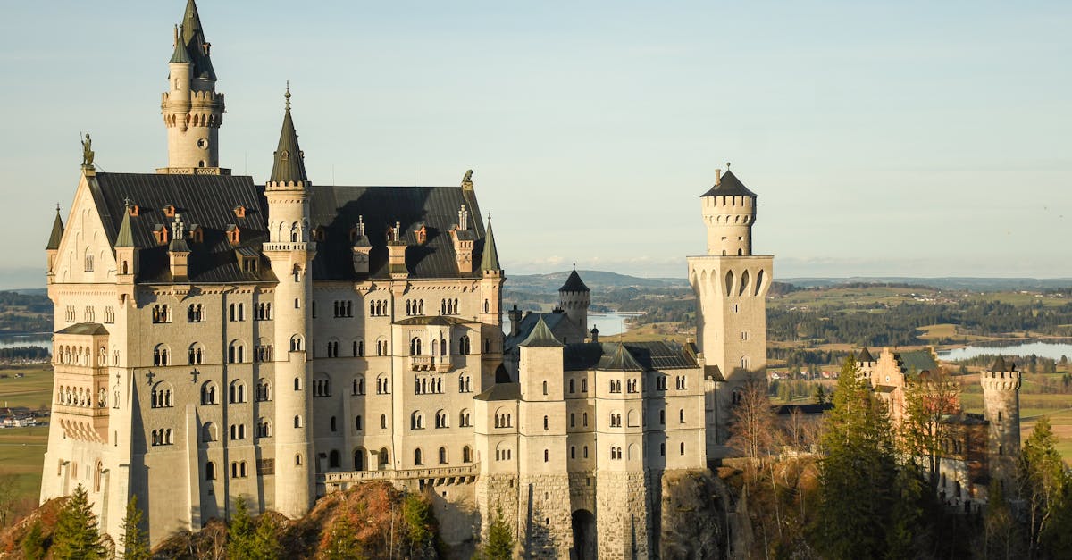 Stunning view of Neuschwanstein Castle in Bavaria, Germany with a clear blue sky at sunset.