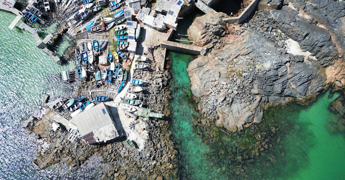Vibrant aerial shot of fishing boats docked at the rocky coast of Arraial do Cabo, Brazil.