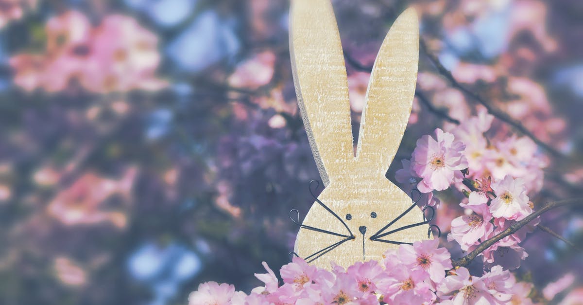 Charming wooden bunny nestled among vibrant cherry blossoms symbolizing spring.