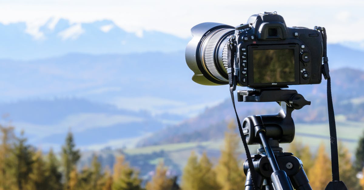 DSLR camera on tripod capturing a stunning mountain view on a clear day.