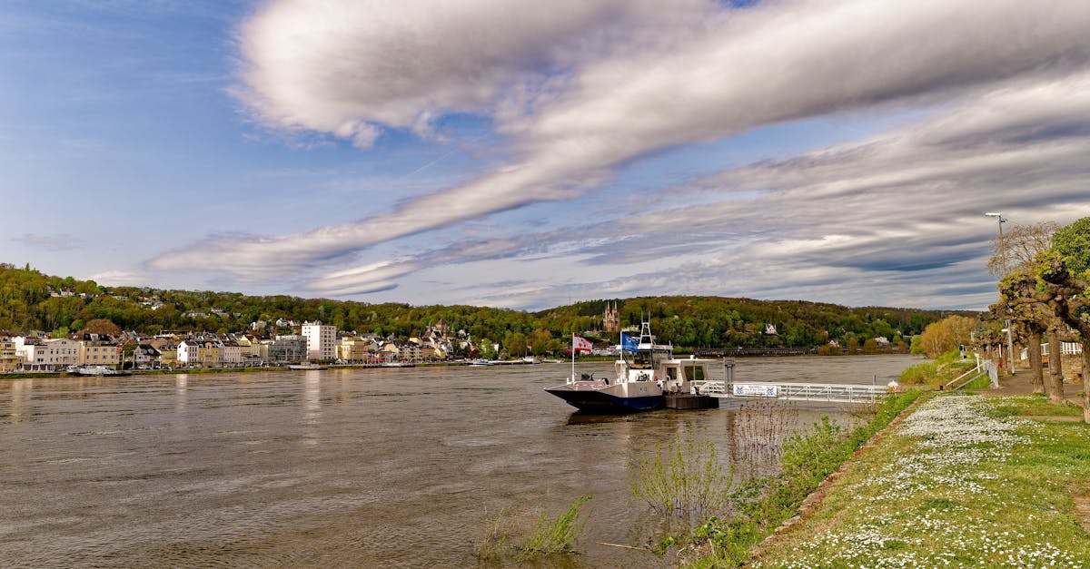 Beautiful view of a ferry docked on the Rhine River in Erpel, Germany, under dramatic clouds.