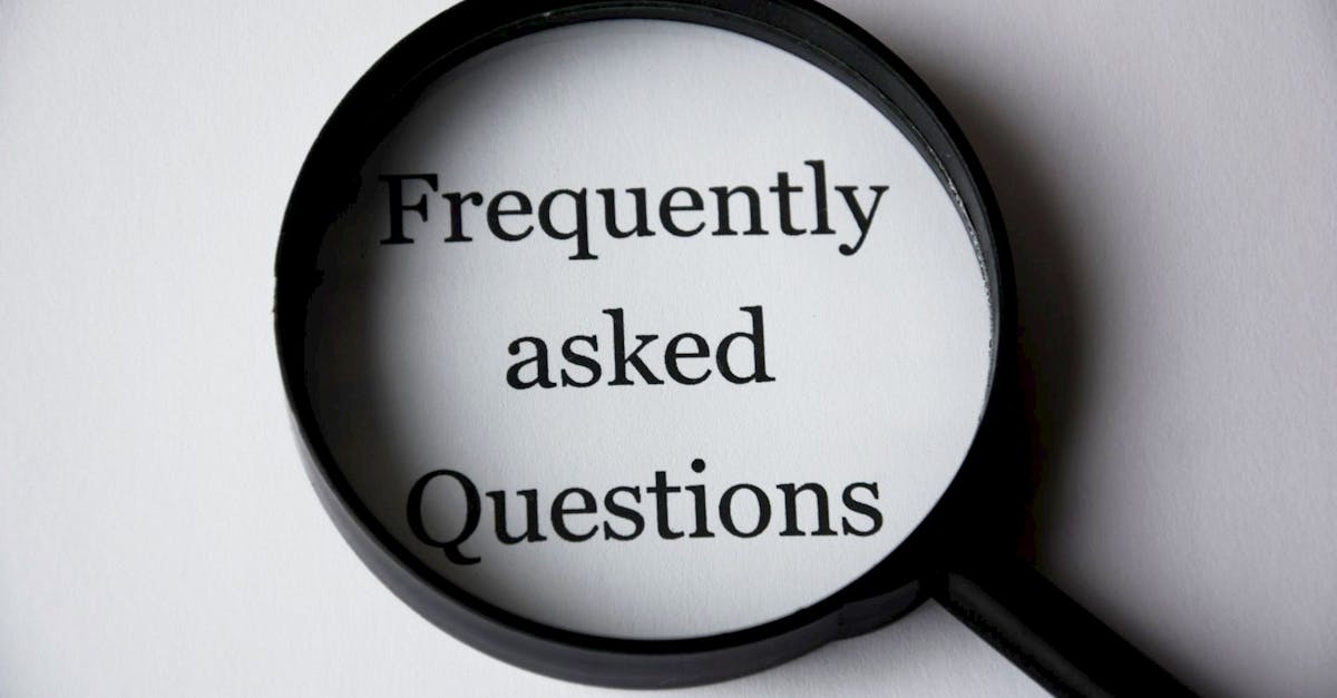 Close-up of a magnifying glass focusing on the phrase 'Frequently Asked Questions'.