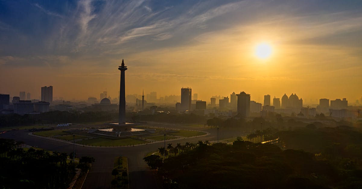 A breathtaking aerial view of Jakarta's skyline and National Monument at sunrise, showcasing cityscape beauty.