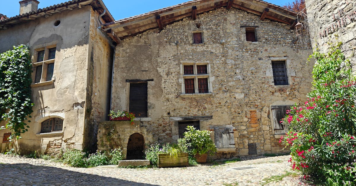 Picturesque view of rustic stone houses in a sunlit historic town street.