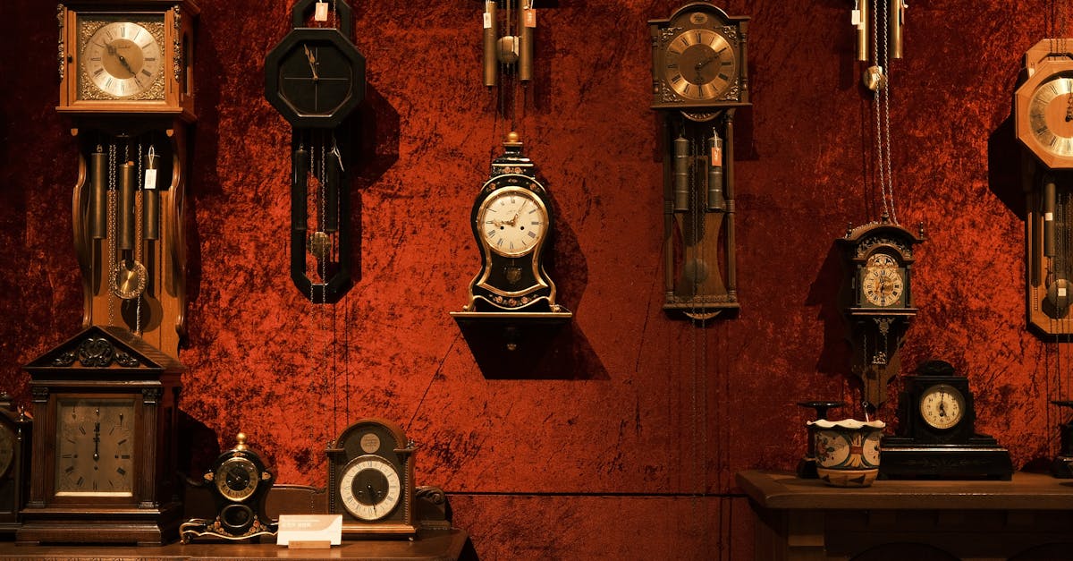 A charming collection of vintage clocks on a red velvet wall, showcasing timeless elegance.