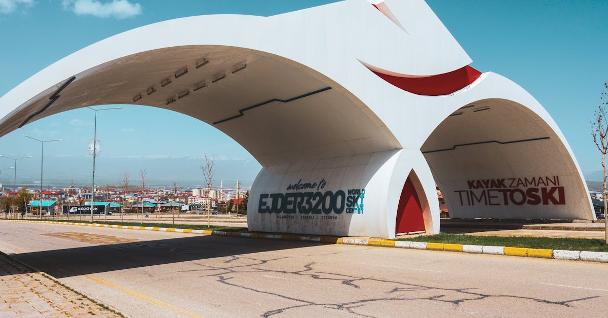 Contemporary arch welcomes visitors at Turkish ski resort on a sunny day.