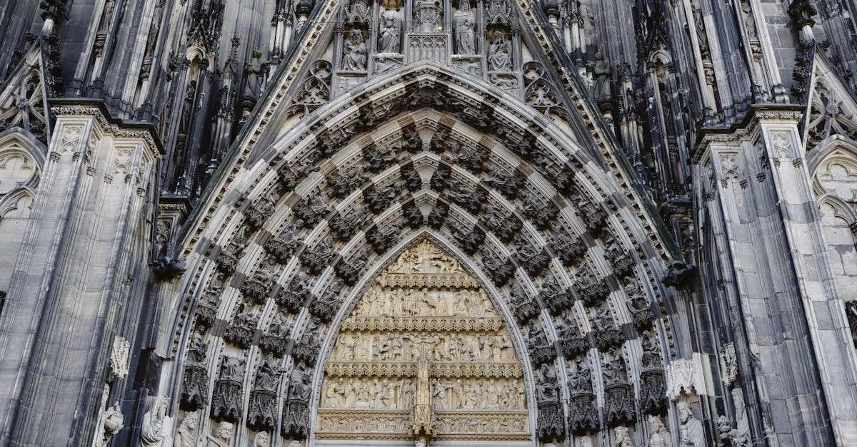Detailed view of a Gothic cathedral's facade featuring intricate stone carvings and statues.