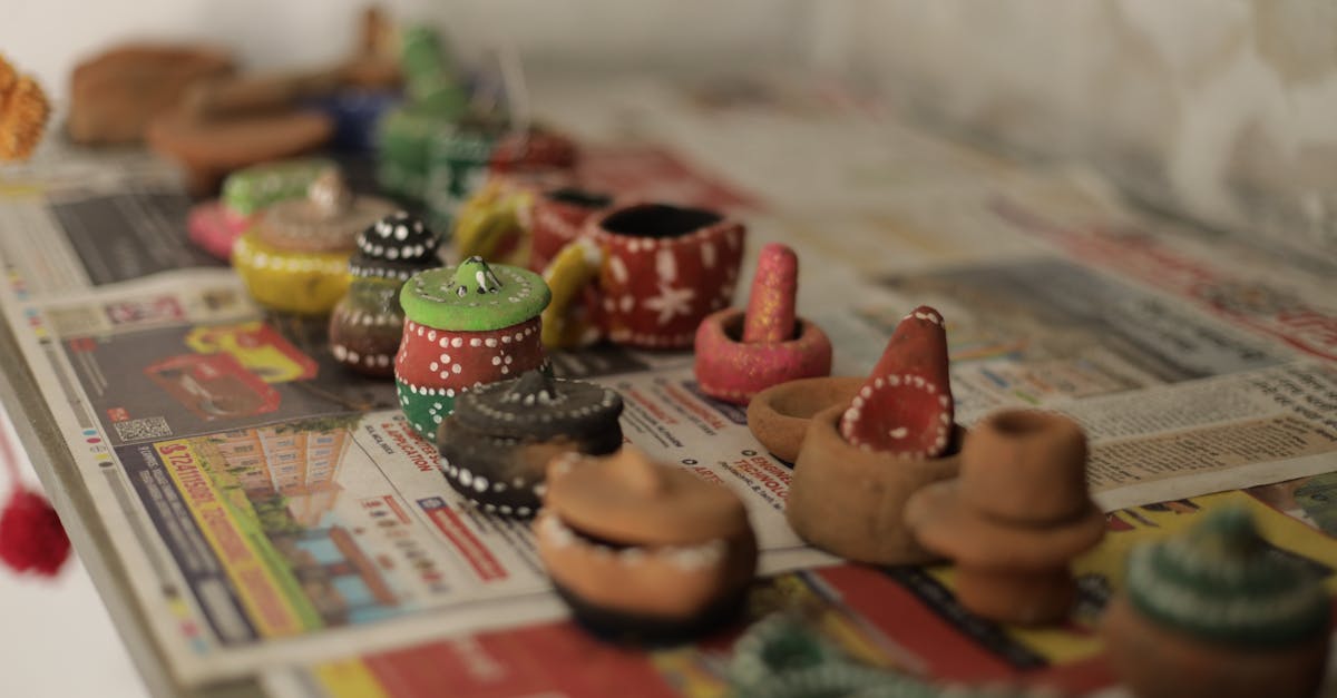 Vibrant mini clay pots and toys arranged on newspaper, showcasing detailed artistry.