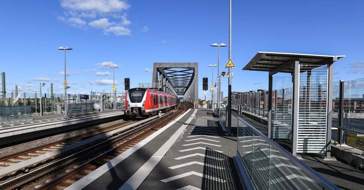 A modern train at Elbbrücken Station in Hamburg, showcasing futuristic architecture under a clear blue sky.