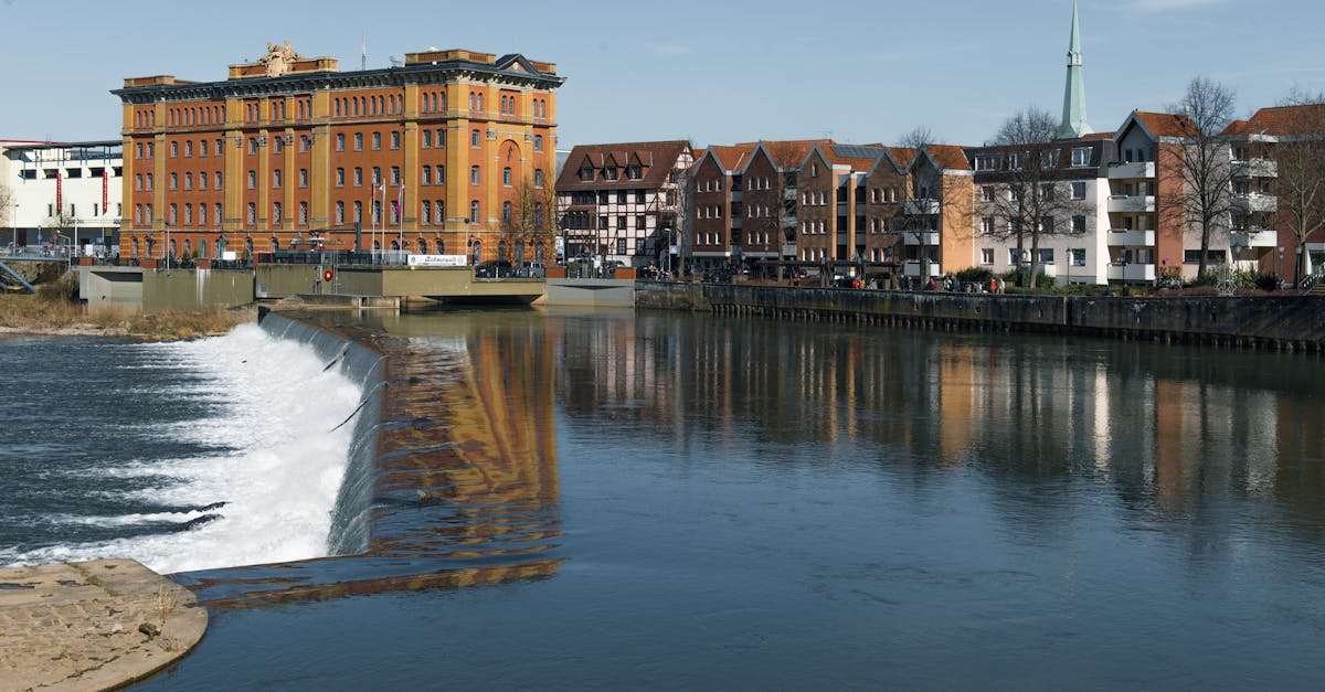 Idyllic riverside view with historic buildings in Hameln, Germany.