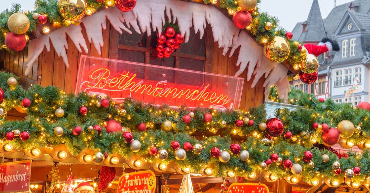 A festive Christmas market stand adorned with lights and holiday decorations at twilight.