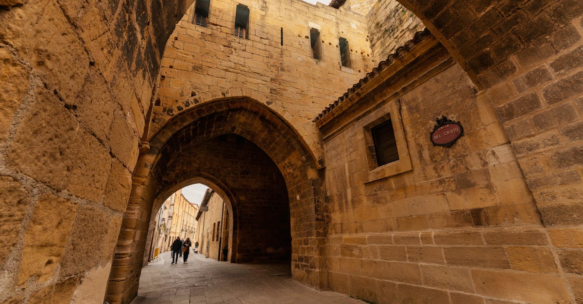 A scenic view of a historic stone archway leading to a medieval town street.