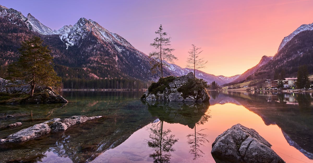 Stunning sunset over Ramsau Lake with snow-capped mountains reflected in the water.