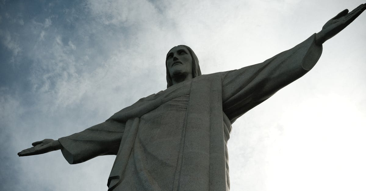 Iconic Christ the Redeemer statue with arms outstretched against a blue sky in Rio de Janeiro, Brazil.
