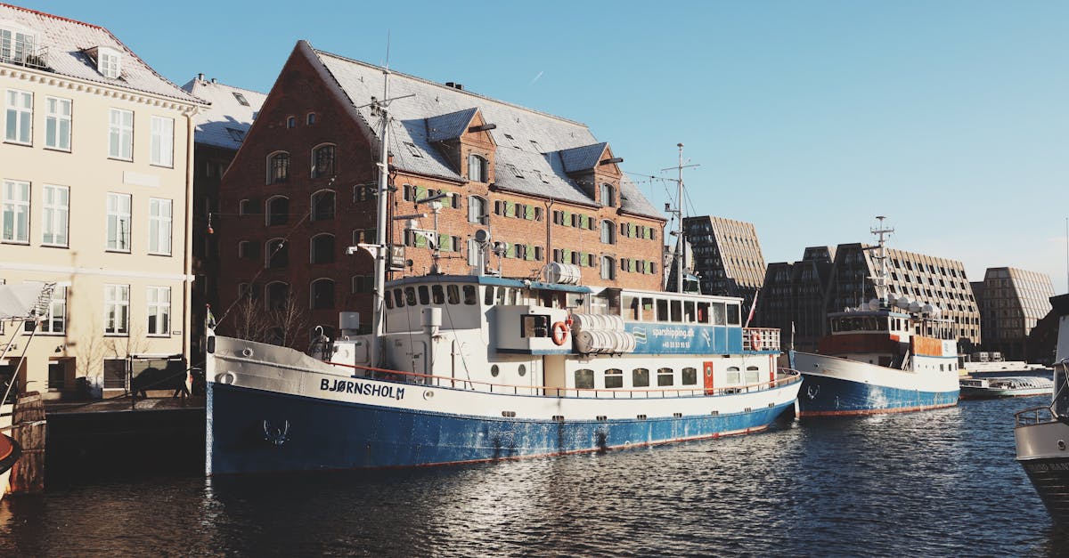 Charming view of Nyhavn Harbor with historic ships and colorful buildings in Copenhagen, Denmark.