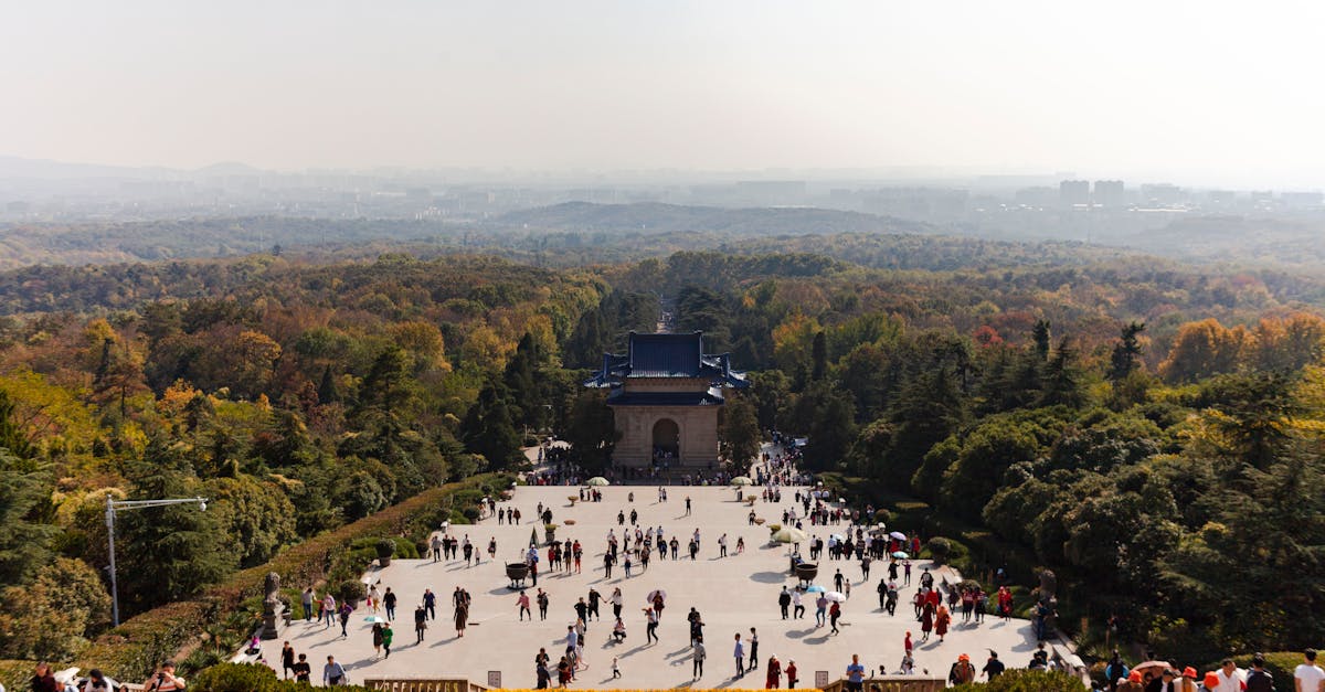 Aerial view of Sun Yat-sen Mausoleum with crowds and lush forest in Nanjing, China.
