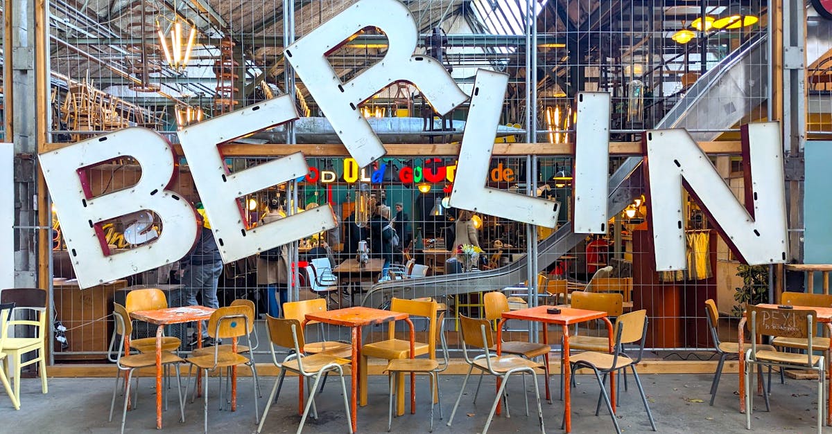 Colorful vintage shop entrance with Berlin sign and retro tables and chairs.