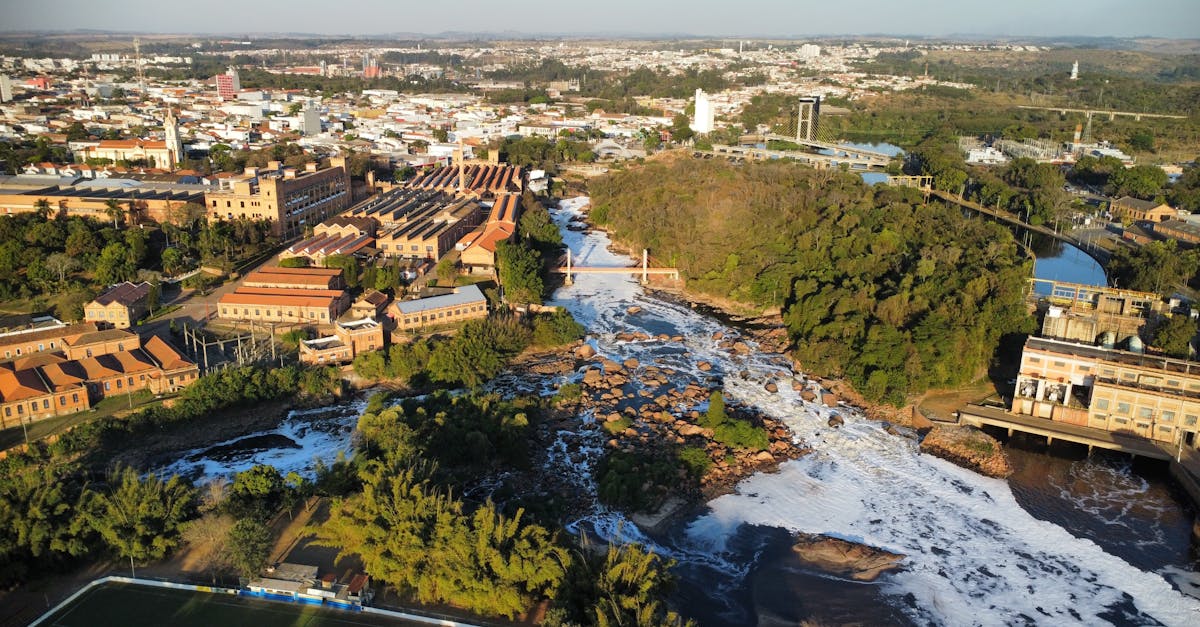 Aerial view of a river flowing through a city near industrial buildings.