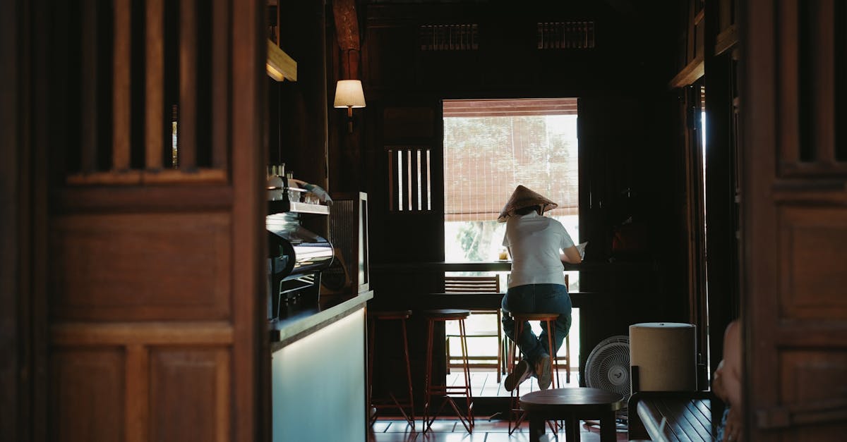 A serene coffee shop interior featuring a lone patron enjoying a quiet moment by the window.