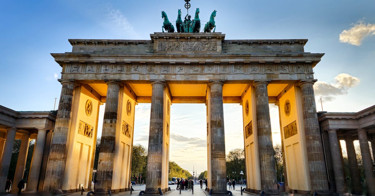 The iconic Brandenburg Gate in Berlin, captured during sunset with glowing light.