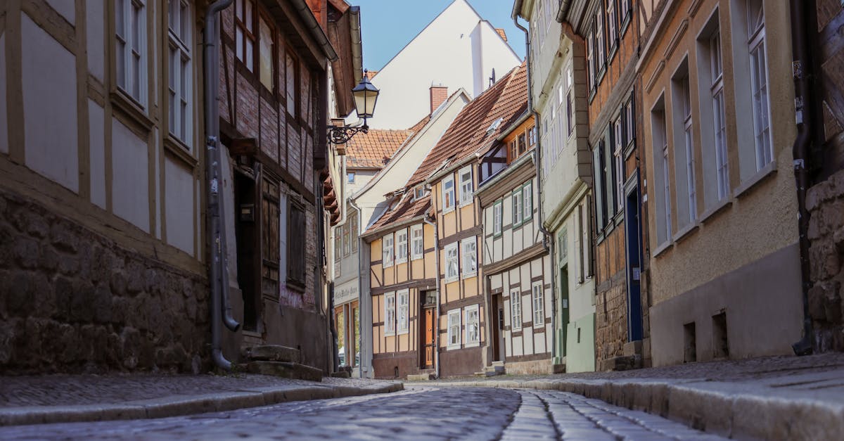 A picturesque cobblestone street with historic half-timbered houses in Quedlinburg, Germany.