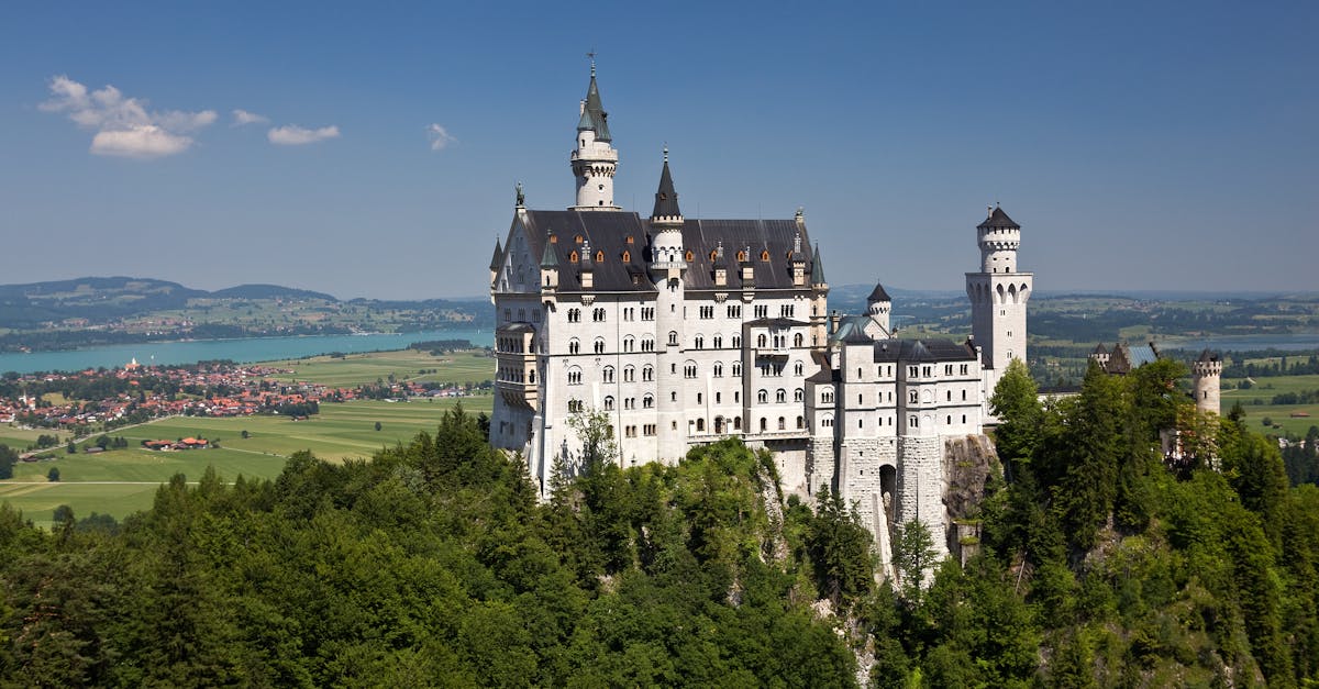 Stunning view of Neuschwanstein Castle amidst lush greenery under a clear blue sky in Bavaria, Germany.
