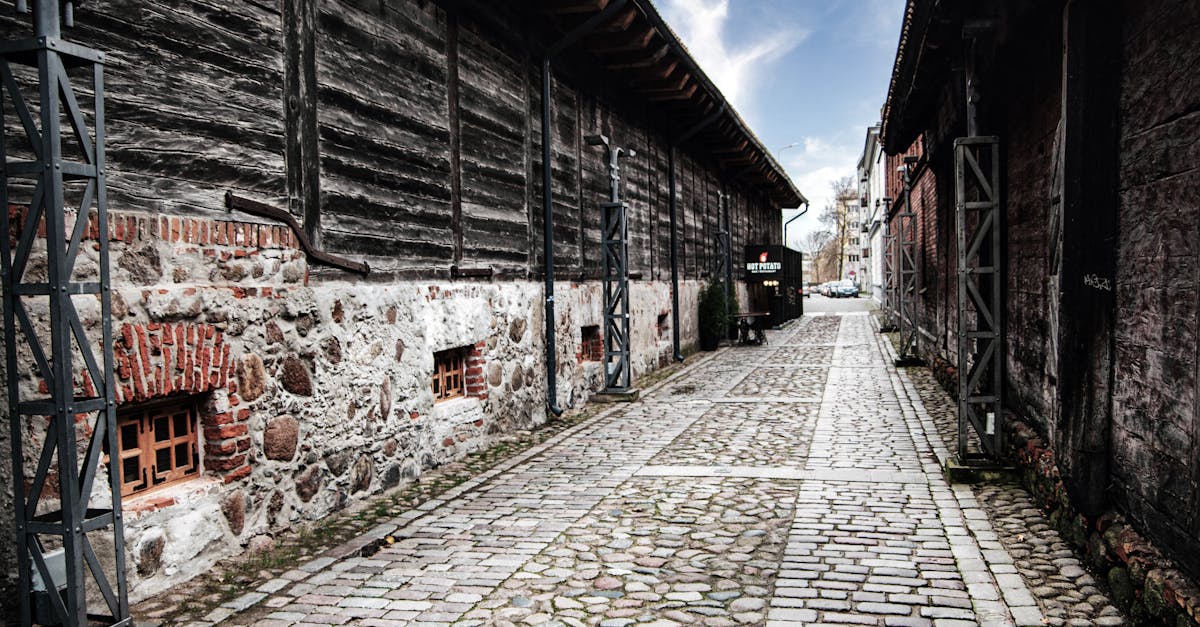 A cobblestone street flanked by medieval buildings in Liepāja's old city, Latvia.