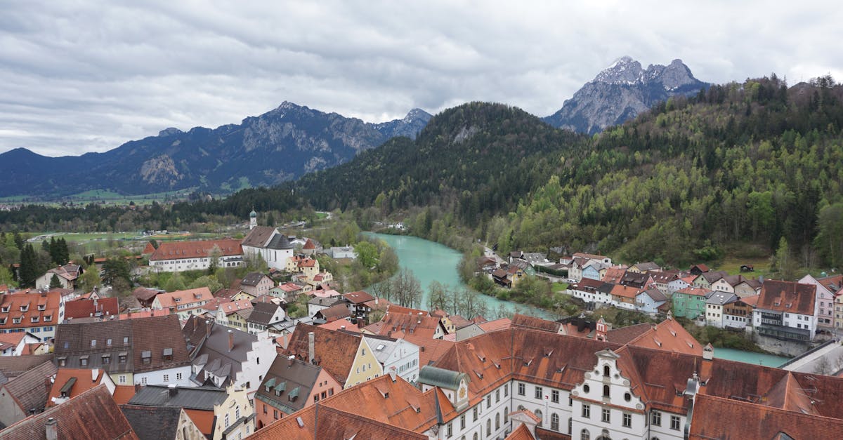 Aerial view of a picturesque Bavarian town surrounded by the Alps and a flowing river.