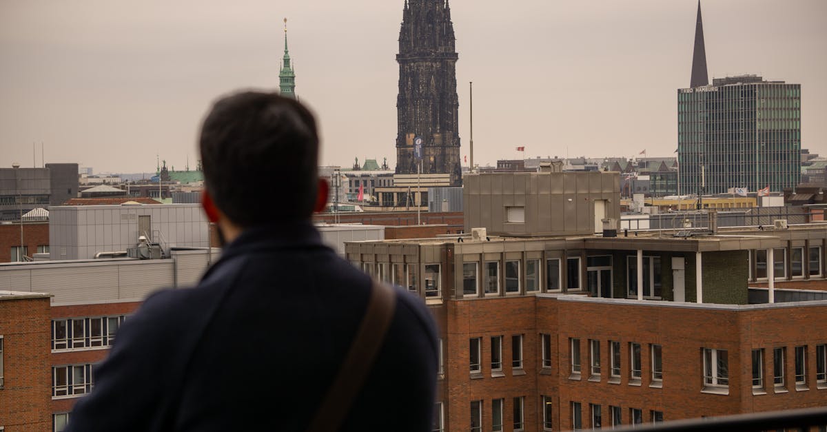 A picturesque view of St. Nikolai Tower in Hamburg with a person admiring the cityscape.