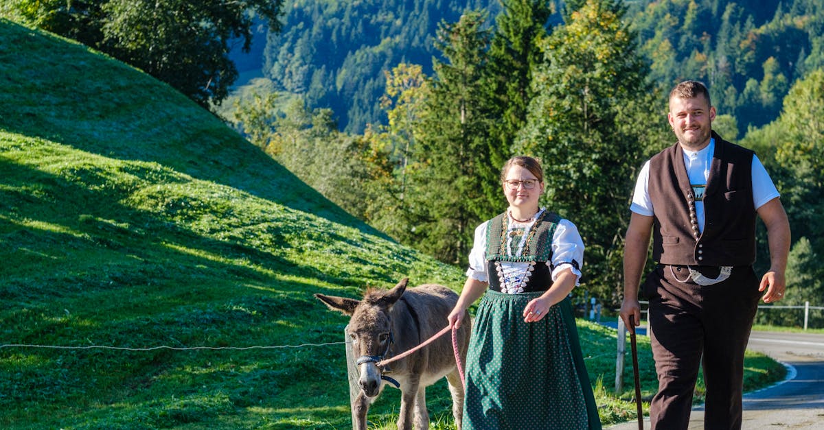A couple in traditional Swiss attire walking a donkey in Appenzell Ausserrhoden, Switzerland.