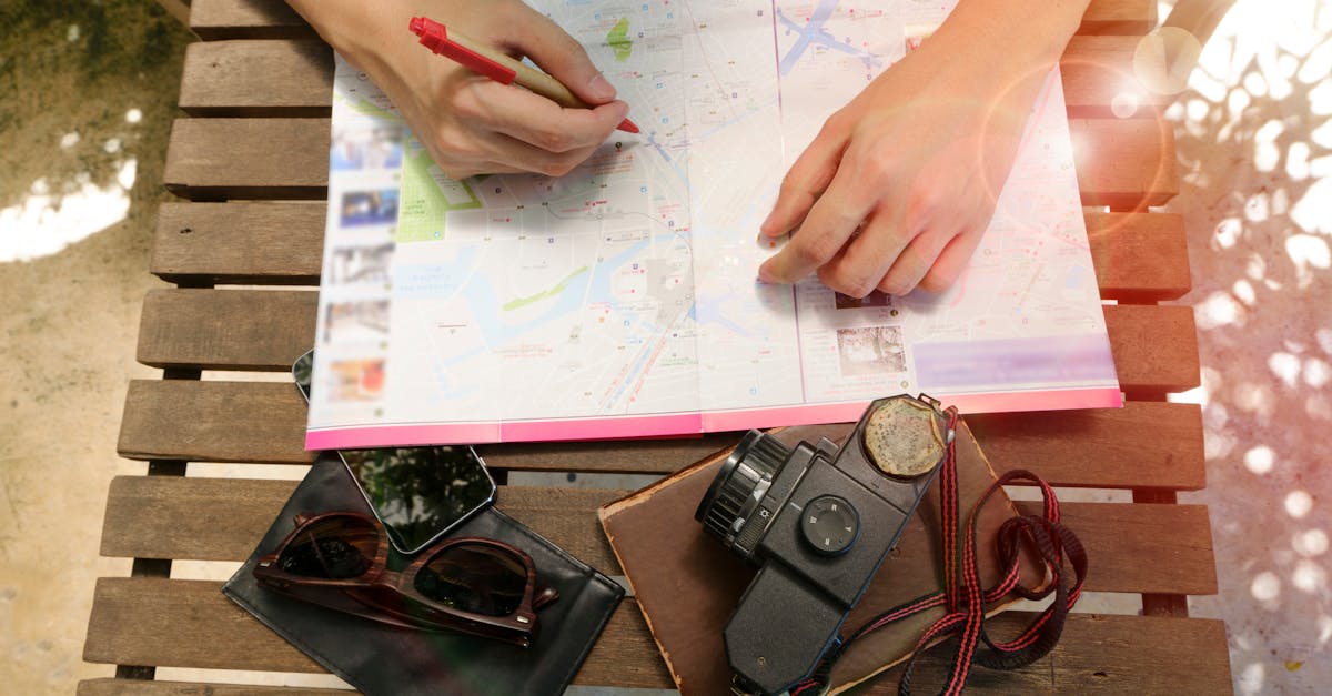 A person planning a journey using a map and vintage camera, evoking travel and exploration.