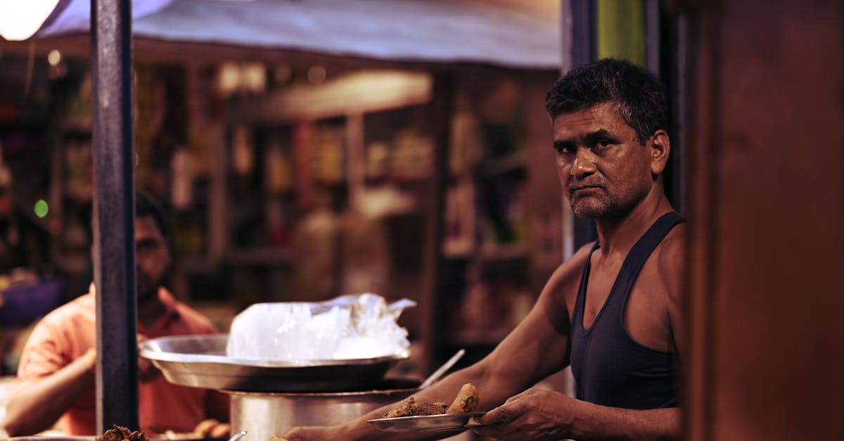 Street vendor preparing traditional Indian snacks at night market stall.