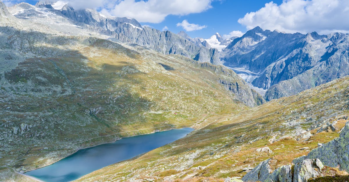 Stunning aerial view of the Swiss Alps with a pristine alpine lake and dramatic mountain range.