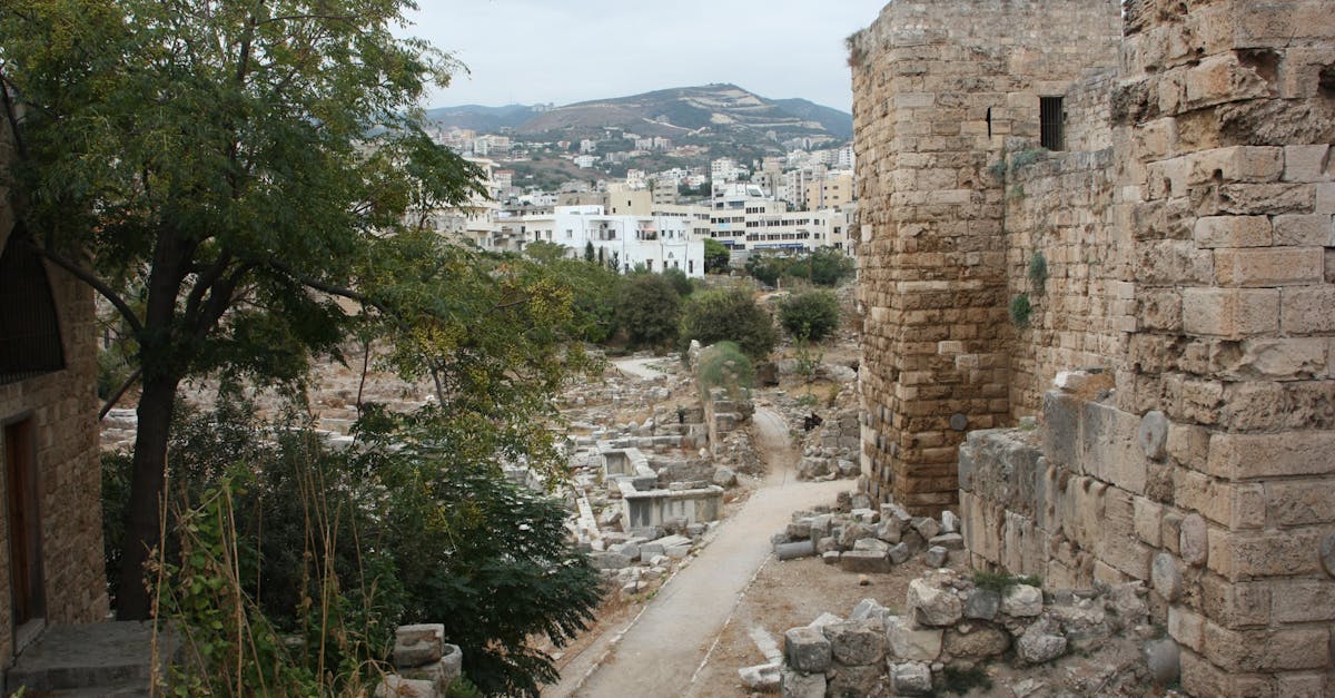 Ancient stone ruins in Byblos, Lebanon with cityscape in the background.